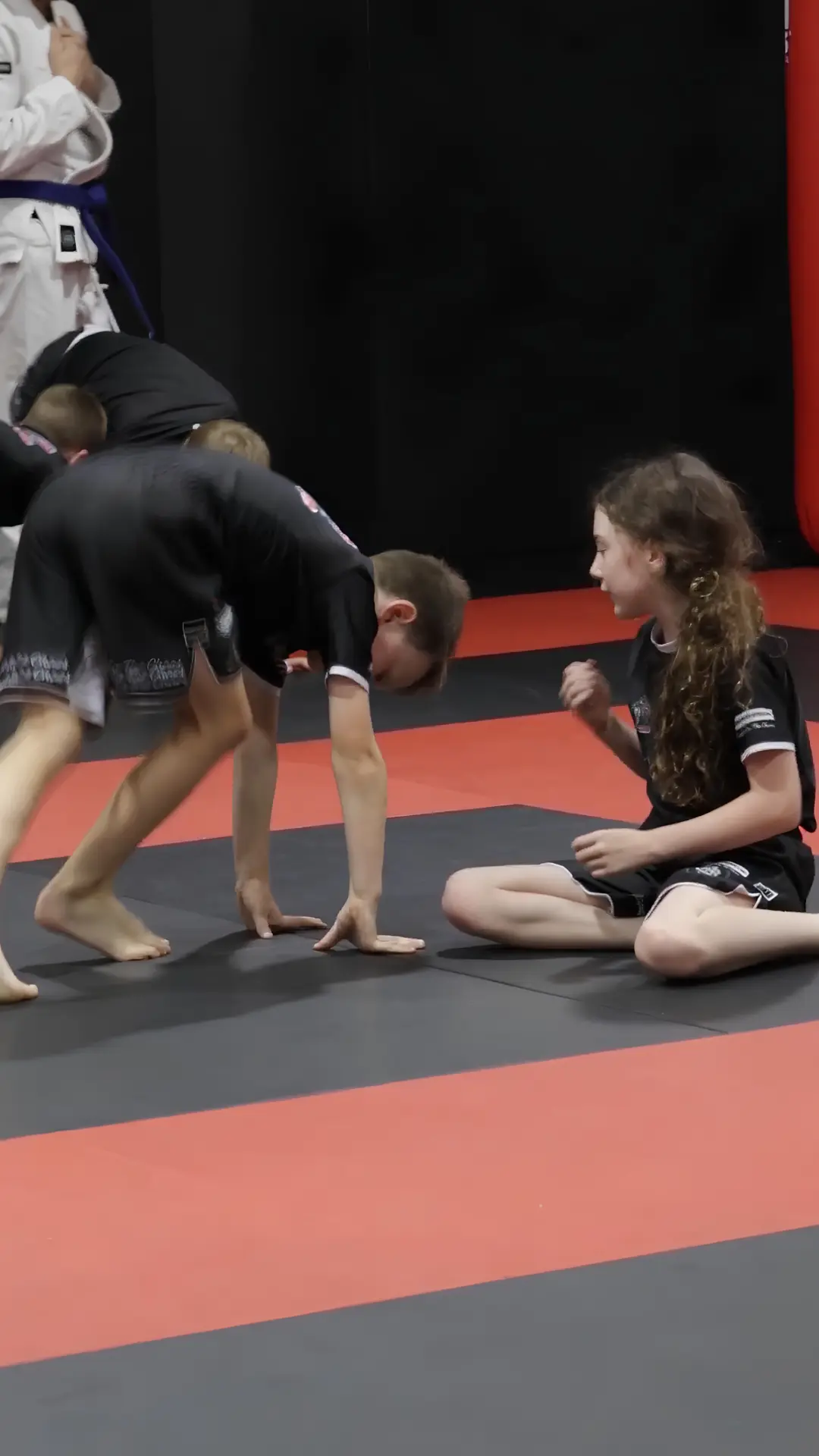 Boy and girl working together on the mats